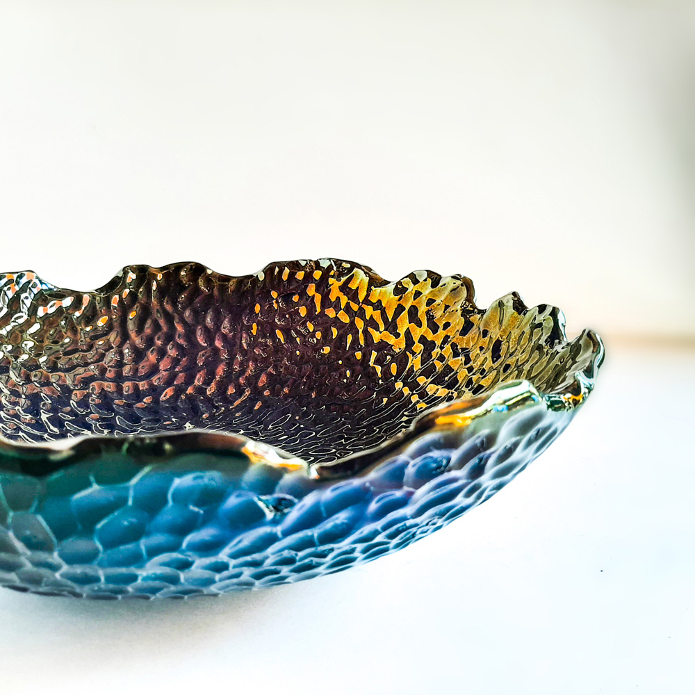 Iridescent ceramic bowl showing golden reflections and wavy rim – Hircan Terralux collection